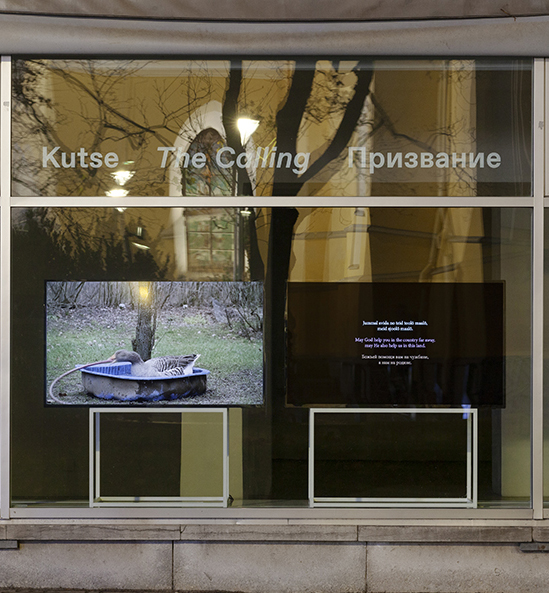 Installationsansicht von “The Calling” mit zwei Bildschirmen in Schaufenster einer Galerie.